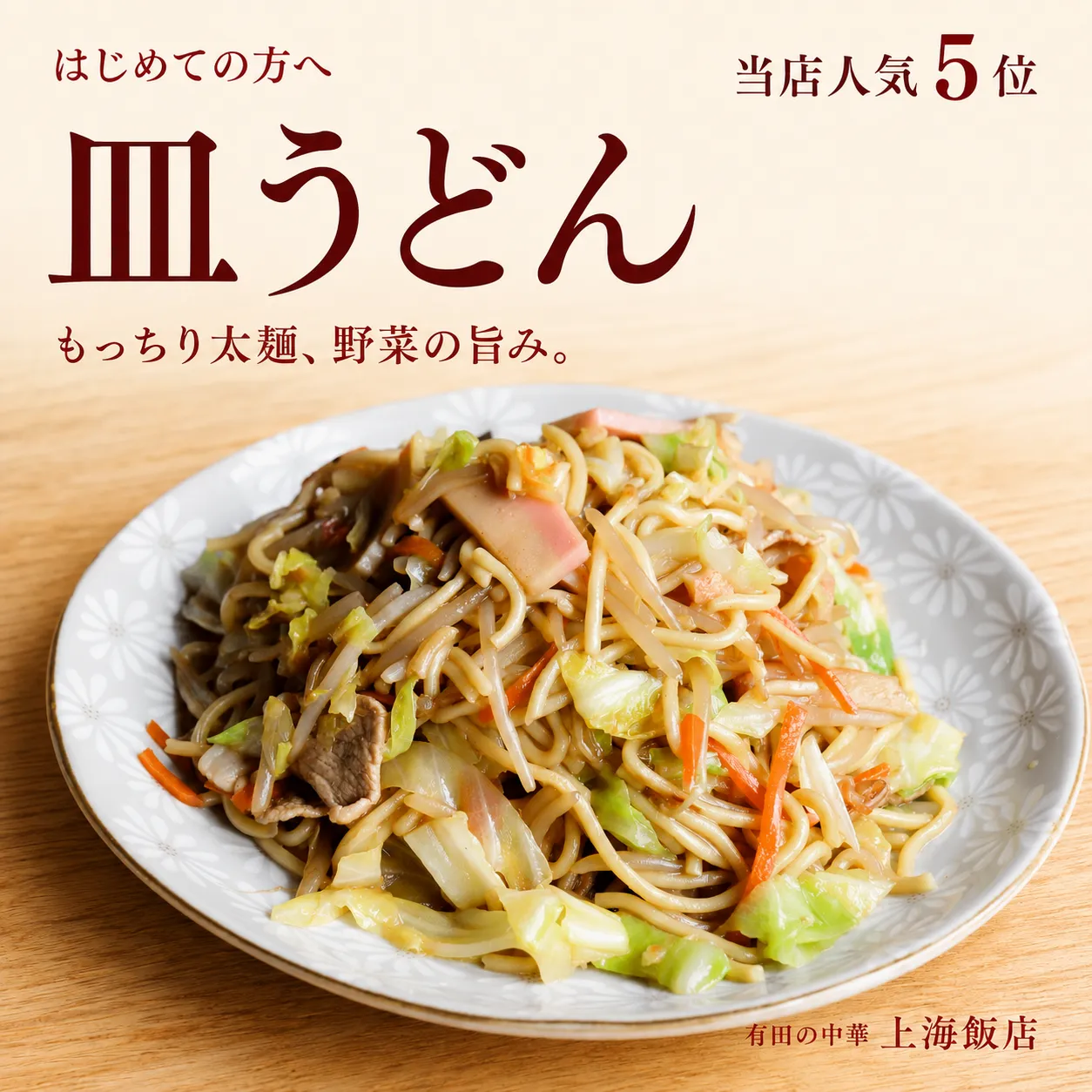 上海飯店の人気5位、太麺の皿うどん。白い柄入りの皿に、もっちりとした麺と野菜を盛り付けた一皿